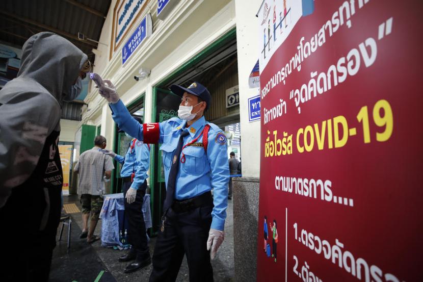 Petugas memeriksa suhu tubuh calon penumpang di sebuah stasiun di Bangkok.Kini total kematian akibat Covid-19 di seluruh Thailand menjadi empat. Ilustrasi. 