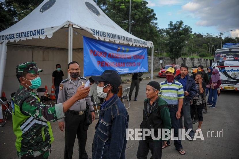 Petugas memeriksa suhu tubuh pemudik yang akan menuju Sumedang di perbatasan Kabupaten Bandung dengan Kabupaten Sumedang di Jatinangor, Kabupaten Sumedang, Jawa Barat, Sabtu (11/4/2020). Pemerintah Kabupaten Sumedang memberlakukan karantina wilayah parsial (KWP) dengan mendirikan posko tim gugus tugas COVID-19 di sejumlah titik perbatasan untuk mencegah penyebaran virus Corona yang mungkin saja dibawa oleh pemudik.