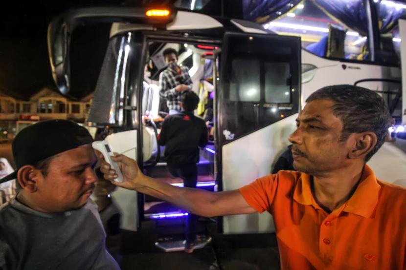 Petugas memeriksa suhu tubuh penumpang di Terminal bus Antar Kota Antar Provinsi (AKAP) Lhokseumawe, Aceh, Rabu (1/4/2020). Penerapan pemeriksaan suhu tubuh dan pemakaian hand sanitizer bagi penumpang antar provinsi itu sebagai langkah antisipasi penyebaran virus Corona (COVID-19).