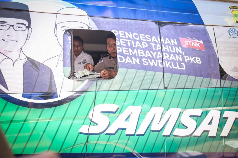 Petugas memeriksa surat kelengkapan bayar pajak dimobil Pajak Keliling Depok Bersama dan Terpadu (PALING DBEST) di Mutiara Depok, Sukmajaya, Depok, Jawa Barat, Kamis (29/7/2022). Pemerintah Provinsi Jawa Barat menggelar Program Pemutihan Pajak Jabar dengan pelayanan bebas denda PKB, bebas bea balik nama kendaraan bermotor kedua, bebas tunggakan PKB tahun kelima, diskon PKB, pengajuan penghapusan dan pengurangan pembayaran pokok PBB yang digelar hingga 31 Agustus 2022.