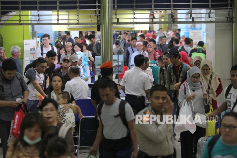  Petugas memeriksa tiket calon penumpang di Stasiun Gambir, Jakarta, Selasa (27/6).