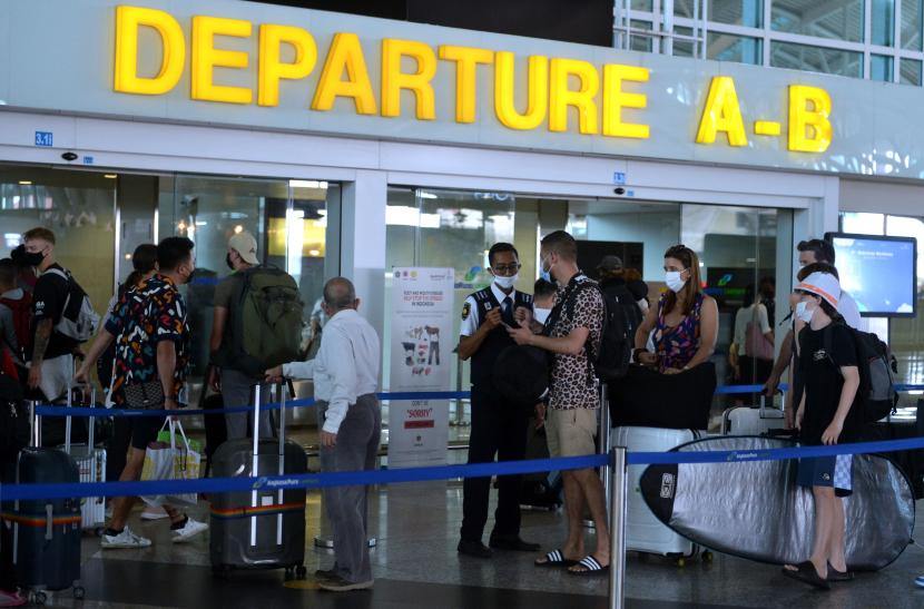 Petugas memeriksa tiket penumpang di area Terminal Internasional Bandara I Gusti Ngurah Rai, Badung, Bali
