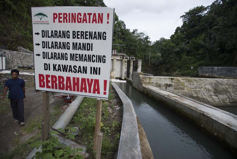 Petugas memeriksa tinggi debit air dari Kali Segara yang menuju ruang turbin Pembangkit Listrik Tenaga Mini Hidro (PLTMH) Segara di Bendungan Air di Desa Bentek, Gondang, Lombok Utara, NTB, Senin (8/12).