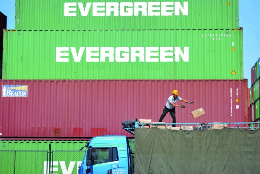 Petugas memindahkan barang impor ke truk di pelabuhan bongkar muat di Qingdao, Provinsi Shandong, China, Senin (14/10). Pemerintah mengantisipasi impor bahan baku penolong untuk industri yang sebagian besar berasal dari china.