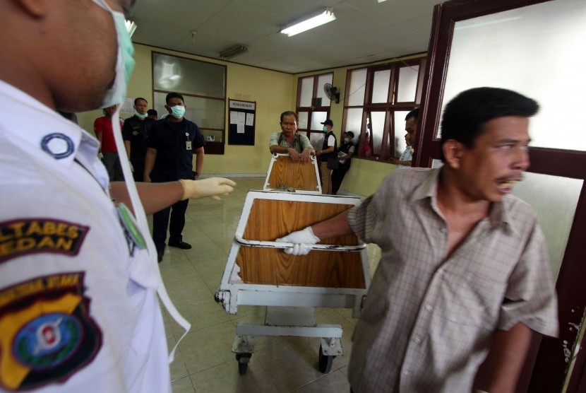 Petugas memindahkan kantong berisi jenazah korban pesawat Hercules C-130 di Rumah Sakit Umum Pusat Adam Malik Medan, Sumatera Utara, Selasa (30/6). (Antara/Septianda Perdana)