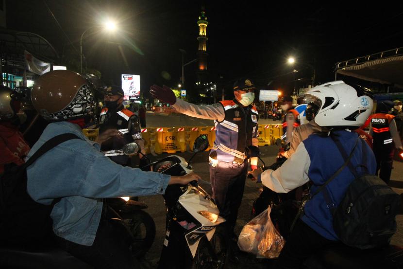 Petugas meminta pengendara kendaraan bermotor untuk berputar balik di Jalan Rungkut Menanggal, Surabaya, Jawa Timur, Kamis (4/6/2020). Jalan penghubung Kota Surabaya-Sidoarjo itu ditutup sementara untuk menekan penyebaran COVID-19.