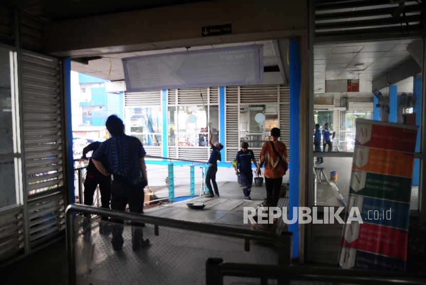 Petugas memperbaiki kerusakan halte bus way Transjakarta, Kampung Melayu, Jakarta timur, Jumat (26/4). 