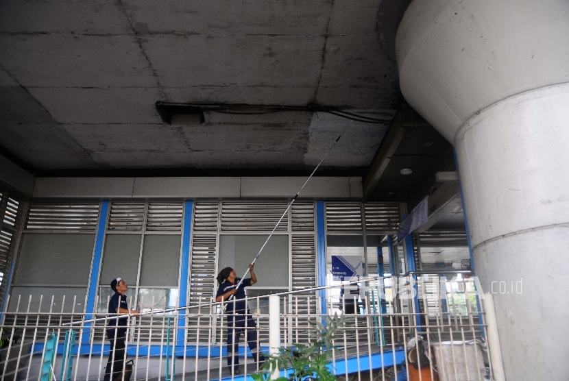 Petugas memperbaiki kerusakan halte bus way Transjakarta, Kampung Melayu, Jakarta timur, Jumat (26/4). 