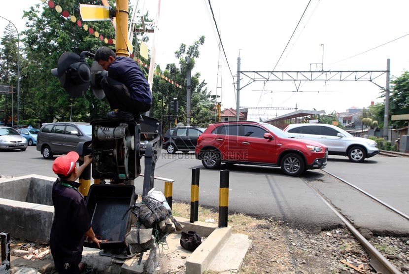 Petugas memperbaiki palang pintu kereta api di Grogol, Jakarta Barat, Senin (1/9). (Republika/ Yasin Habibi)