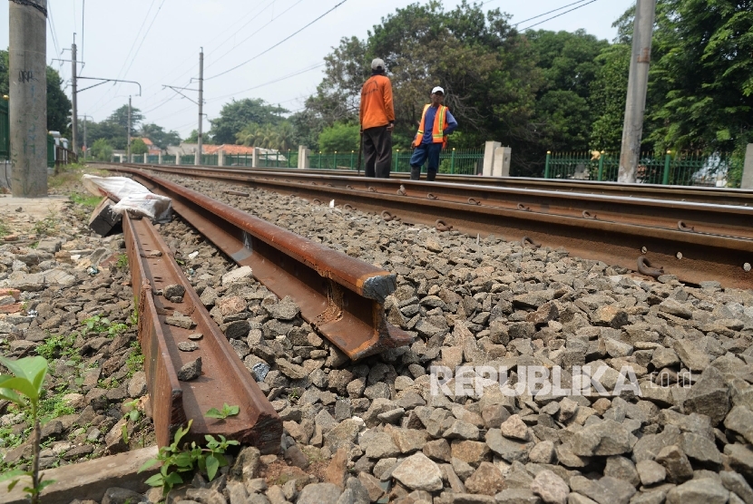 Petugas memperbaiki rel kereta api yang patah di perlintasan Lenteng Agung - Pasar Minggu, Jakarta Selatan, Selasa (19/1).   (Republika/Yasin Habibi)