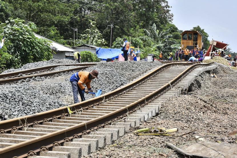 Petugas memperbaiki rel kereta yang rusak akibat banjir di Kedungwaringin, Kabupaten Bekasi, Jawa Barat, Senin (22/2/2021).