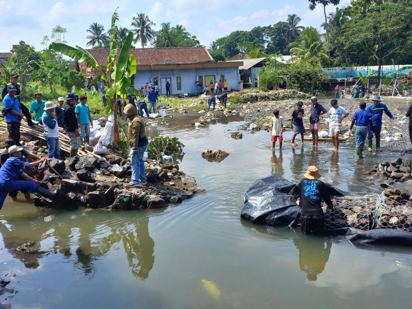 Petugas memperbaiki tanggul di Sungai Dalemsuba di Kecamatan Purbaratu, Kota Tasikmalaya, Ahad (17/4/2022). Tanggul di sungai itu jebol pada Jumat (15/4/2022) dan mengakibatkan banjir bandang. 