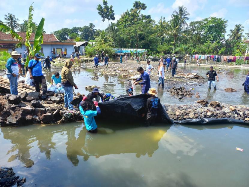 Petugas memperbaiki tanggul di Sungai Dalemsuba di Kecamatan Purbaratu, Kota Tasikmalaya. Tanggul di sungai itu jebol pada Jumat (15/4/2022) dan mengakibatkan banjir bandang. 