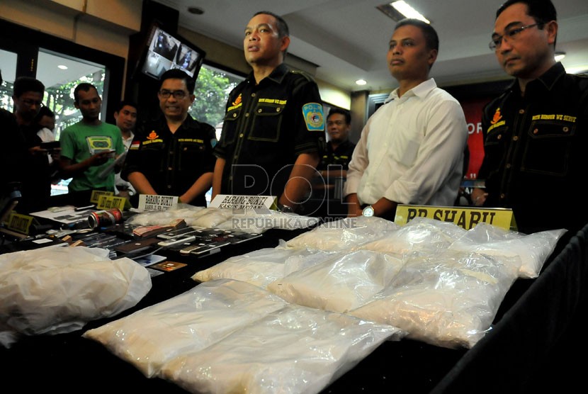   Petugas memperlihatkan barang bukti beserta tersangka jaringan narkoba internasional kepada wartawan di Jakarta, Senin (11/11).  (Republika/Prayogi)