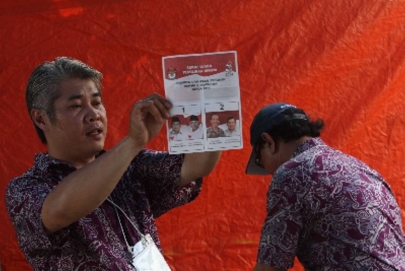 Petugas memperlihatkan surat suara sah kepada saksi pada penghitungan surat suara pilpres 2014 di TPS 04 Kel Taman Sari, Jakarta, Rabu (9/7).