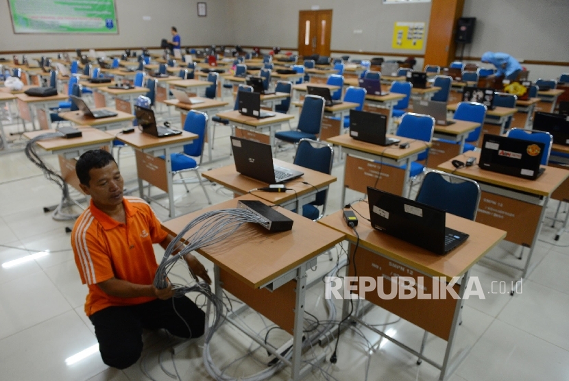 Petugas mempersiapkan peralatan untuk Ujian Nasional Berbasis Komputer (UNBK) di SMP Negeri 12, Jakarta, Sabtu (7/5).