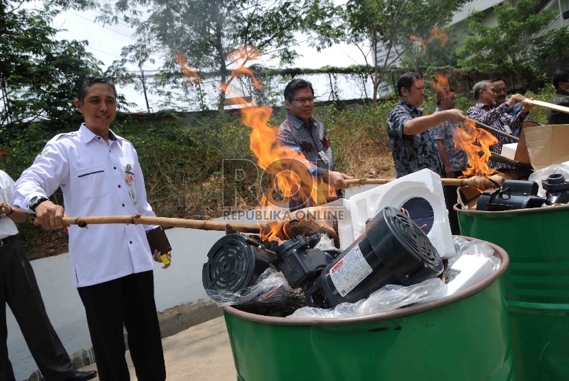  Petugas memusnahkan lampu dan pompa air listrik yang tidak sesuai Standar Nasional Indonesia (SNI) di halaman Gedung Kementerian Perdagangan, Jakarta, Kamis (29/10).  (Republika/Agung Supriyanto)