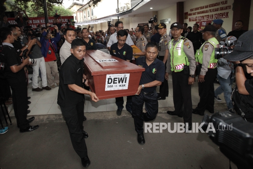 Petugas menaikkan jenazah tebakarnya kapal Zahro Express Dewi ke dalam mobil jenazah untuk diberikan kepada keluarga di RS Polri Sukanto, Kramatjati, Jakarta, Senin (2/1).