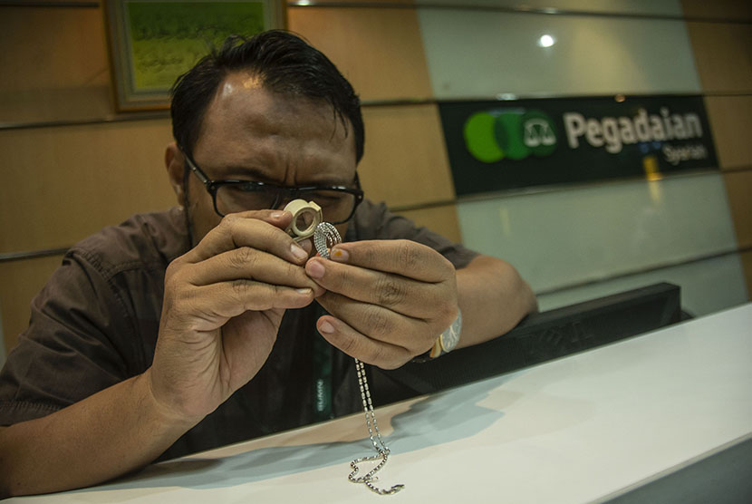 Petugas menaksir emas milik nasabah di Kantor Pusat Pegadaian, Jakarta, Kamis (7/6). 