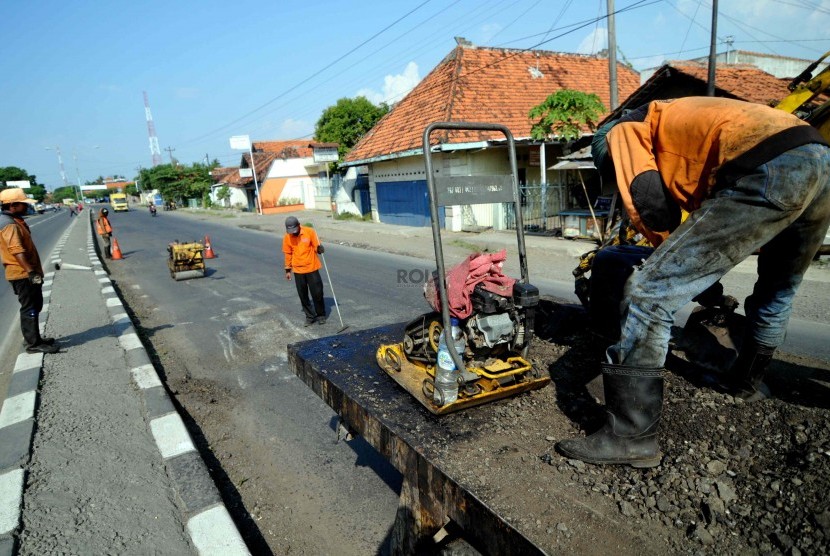Petugas menambal jalan di Brebes, Jawa Tengah, Senin (21/7). (Republika/ Wihdan).