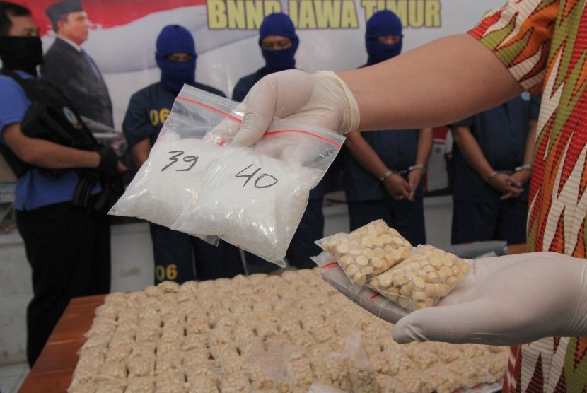 Petugas menampilkan tersangka serta barang bukti narkoba saat ungkap kasus peredaran narkoba di Badan Narkotika Nasional Provinsi (BNNP) Jatim, Surabaya, Jawa Timur