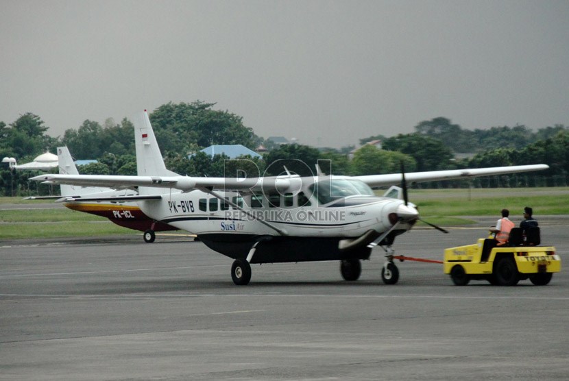   Petugas menarik sebuah pesawat di Bandara Halim Perdana Kusuma, Jakarta, Selasa (7/1).    (Republika/Yasin Habibi)