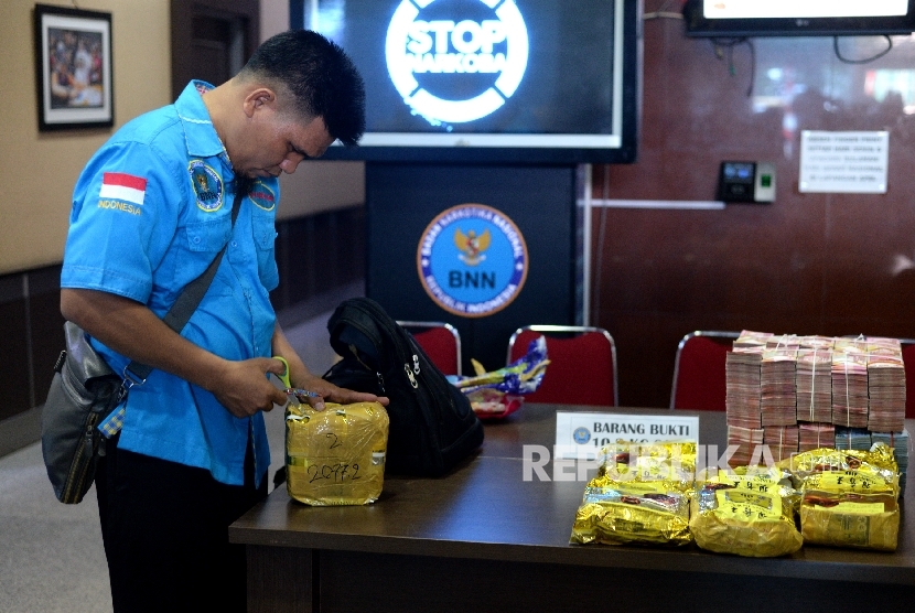 Petugas menata barang bukti uang tunai dan sabu sebelum rilis pengungkapan penyelundupan narkotia di perbatasan di BNN, Jakarta, Selasa (12/9)