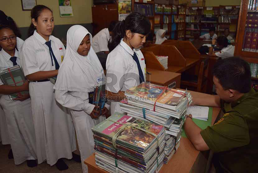 petugas menata buku-buku kurikulum 2013 yang dikemblikan siswa kepada pihak sekolah di Sekolah Menegah Pertama Negeri 56, Jakarta Selatan, Senin (15/12).