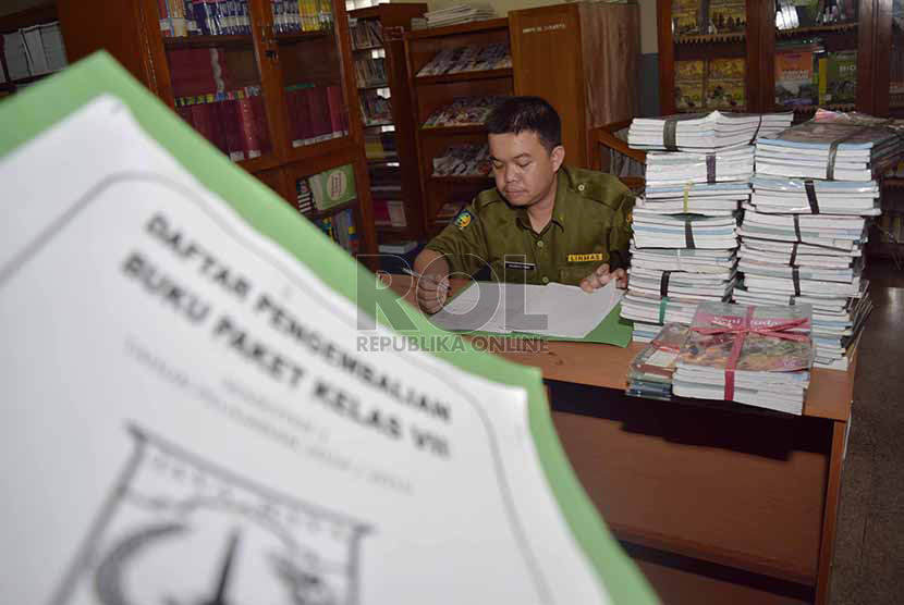 petugas menata buku-buku kurikulum 2013 yang dikemblikan siswa kepada pihak sekolah di Sekolah Menegah Pertama Negeri 56, Jakarta Selatan, Senin (15/12).