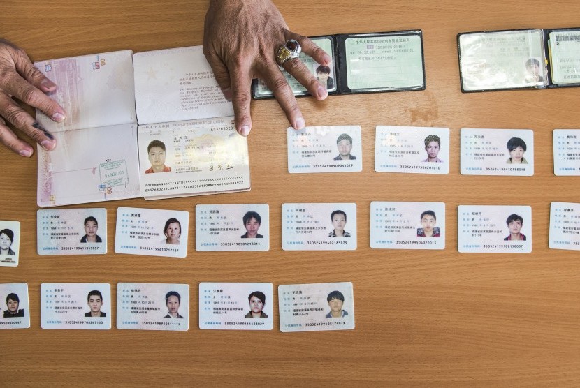 Petugas menata kartu identitas puluhan WNA asal Tiongkok yang ditangkap Polda Metro Jaya karena pelanggaran pidana cyber crime dan keimigrasian saat gelar perkara di kantor Imigrasi Kelas I Jakarta Utara, Jakarta, Senin (30/11). 