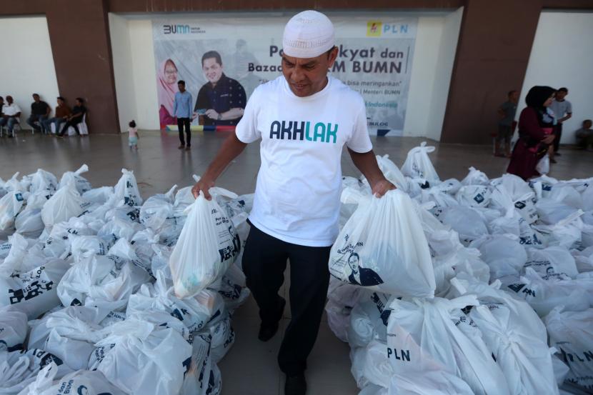 Petugas menata paket sembako yang disediakan saat pasar rakyat dan bazar UMKM BUMN di Taman Ratu Safiatuddin, Banda Aceh, Aceh, Jumat (19/8/2022). Pasar rakyat dan bazar UMKM BUMN yang diselenggarakan PT PLN (Persero) bersama Perum Bulog dan BUMN lainnya menyediakan 4.000 paket sembako berupa lima kilogram beras, satu kilogram gula pasir dan satu kilogram minyak goreng yang dijjual Rp55.000 per paket sebagai upaya meringankan kebutuhan masyarakat. 