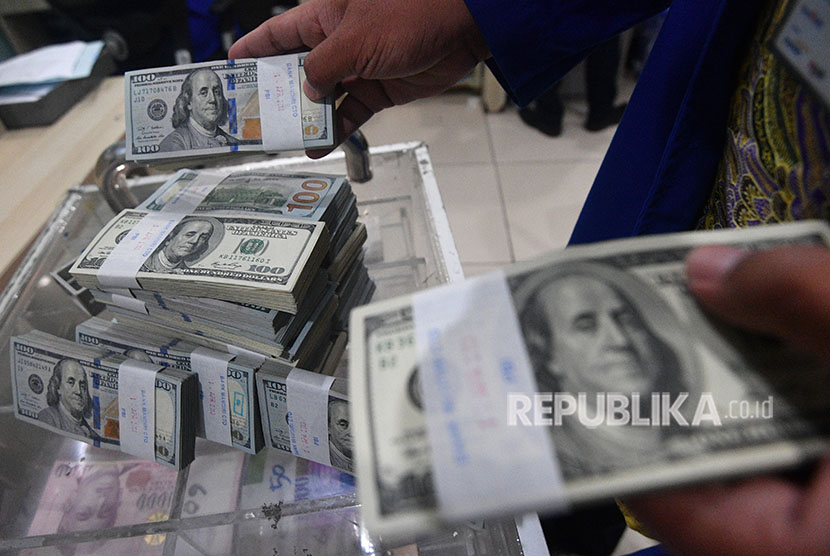 Petugas menata tumpukan uang dolar AS di Cash Center Bank Mandiri, Jakarta, Rabu (18/4).
