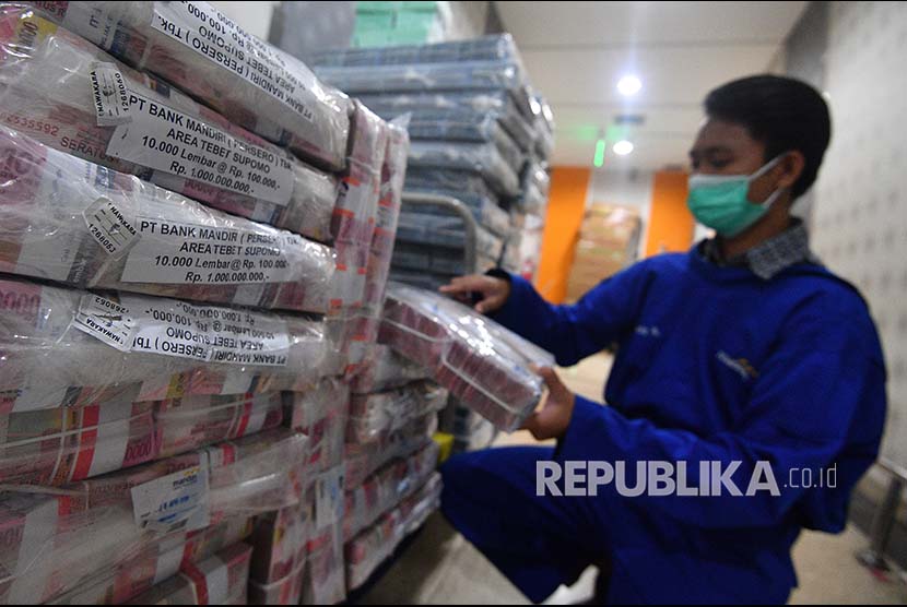 Petugas menata tumpukan uang rupiah di Cash Center Bank Mandiri, Jakarta, Rabu (18/4). Pemerintah dan Bank Indonesia mempertimbangkan untuk menurunkan batas transaksi tunai atau dengan uang kartal yang dalam Rancangan Undang-Undang tentang Pembatasan Transaksi Uang Kartal (PTUK) saat ini diusulkan maksimal Rp100 juta.
