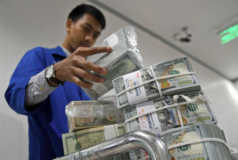 Petugas menata uang Dolar AS di Cash Pooling Bank Mandiri, Jakarta, Kamis (28/11/2019). 