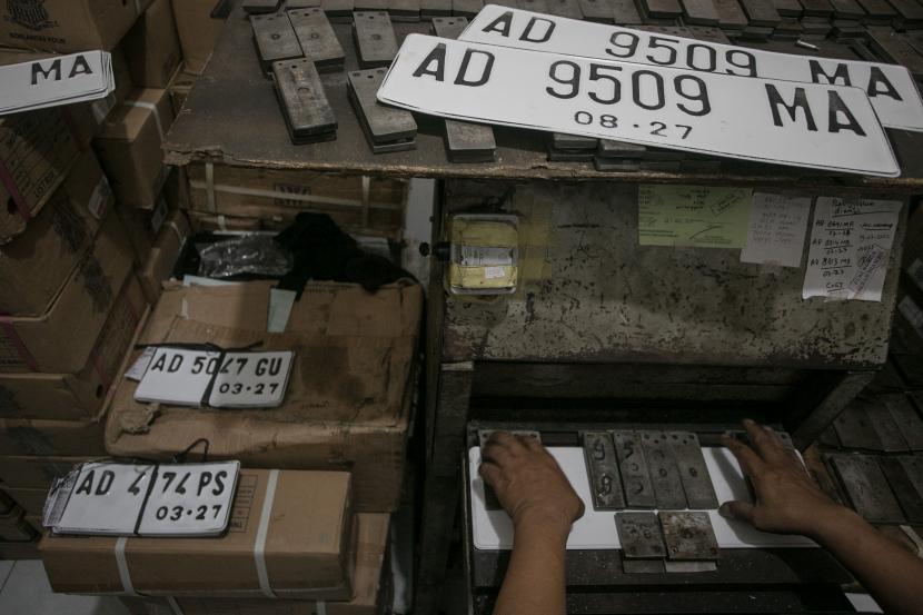 Petugas mencetak pelat nomor putih di kantor Samsat Solo, Jawa Tengah, Rabu (31/8/2022). Korlantas Polri menghentikan penerbitan pelat nomor RF/RFS. (ilustrasi)