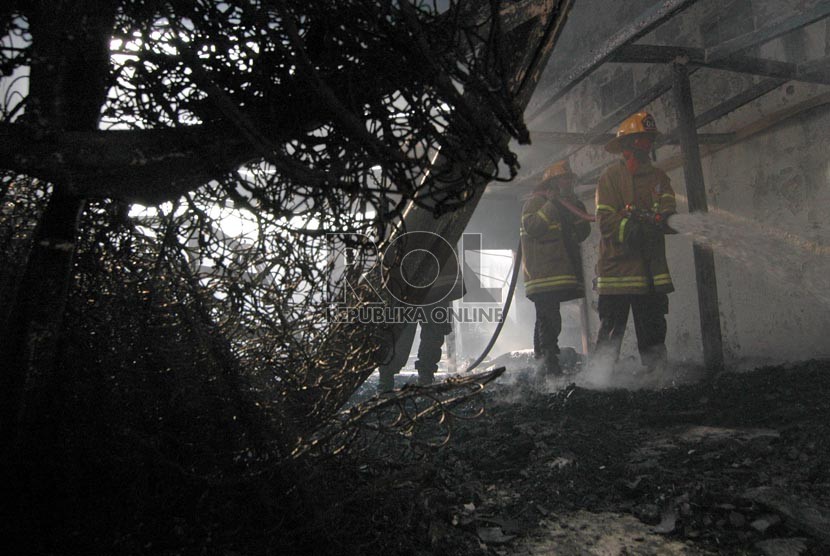  Petugas mencoba memadamkan api yang membakar gudang mebel di Jalan Cimindi, Kota Cimahi, Jumat (21/8).  (Foto : Septianjar Muharam)