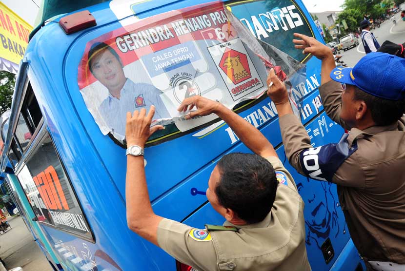  Petugas mencopot stiker calon legislatif (caleg) yang dipasang dikaca angkutan kota (angkot) saat melintas di jalur pantura Jalan Jenderal Sudirman, Brebes, Jateng, Rabu (29/1).    (Antara/Oky Lukmansyah)