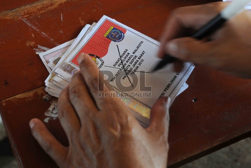 Petugas mencoret kertas suara yang tidak terpakai saat penghitungan perolehan suara di TPS 23, Kelurahan Pondok Jaya, Kecamatan Cipayung, Kota Depok, Jawa Barat, Rabu (9/12).