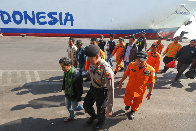 Petugas mendampingi sejumlah korban selamat kapal terbakar KM Santika Nusantara, di dermaga Jamrud Utara, Pelabuhan Tanjung Perak Surabaya, Jawa Timur, Ahad (25/8/2019).