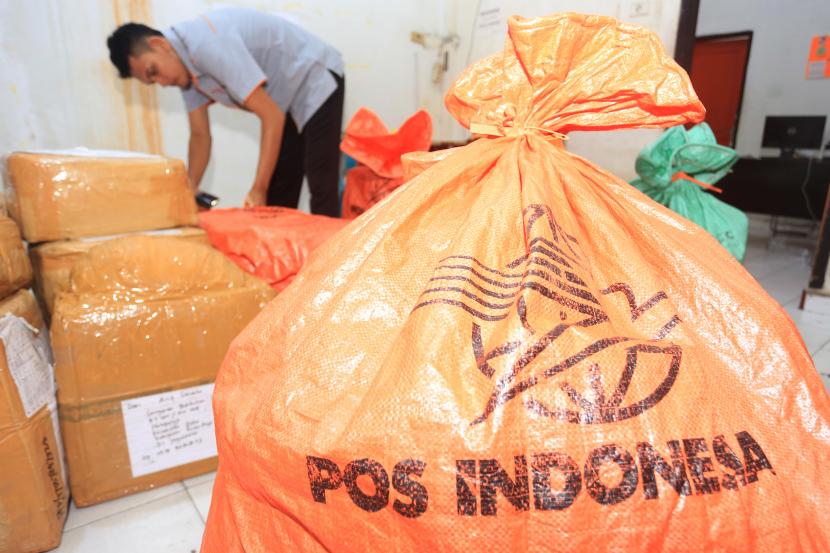 Petugas mendata dan menyortir paket barang kiriman sebelum didistribusikan melalui PT Pos Indonesia (Persero).