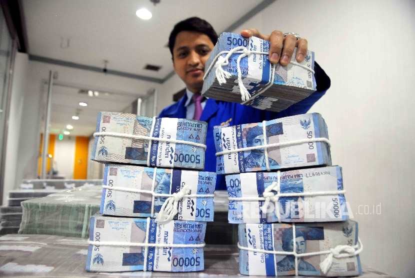 Petugas mendata uang Rupiah di ruang penyimpanan uang Bank Mandiri, Jakarta, Selasa (15/11).