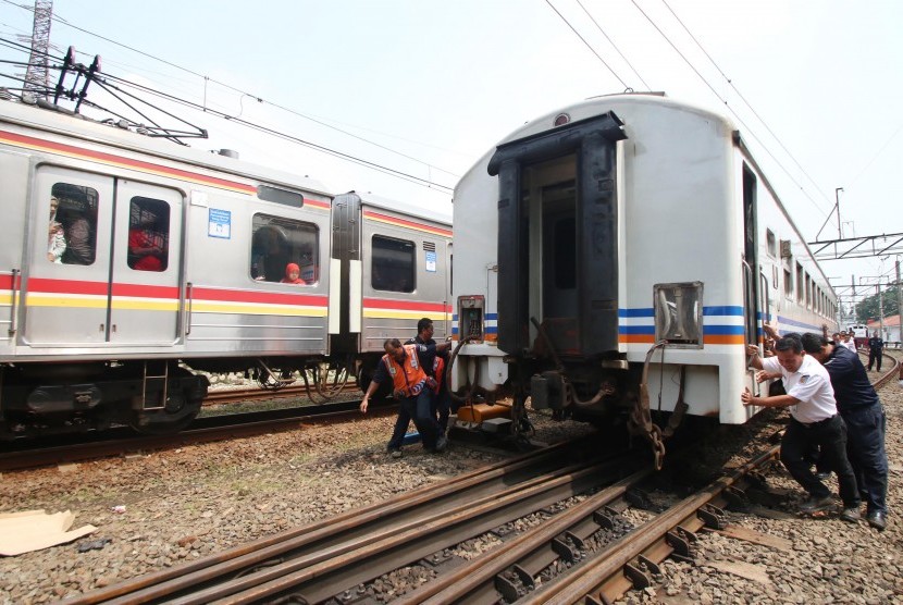 Petugas mendorong Kereta Api (KA) Senja Utama Solo yang mengalami anjlok di Stasiun Tanah Abang, Jakarta, Kamis (10/3).