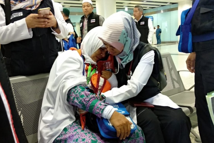  Petugas menenangkankan Asmia Hadi Hasan, seorang jamaah asal Gowa, Sulawesi Selatan, yang ditinggal wafat ibunya di Bandara Amir Muhammad bin Abdulaziz, Madinah, Jumat (20/7).