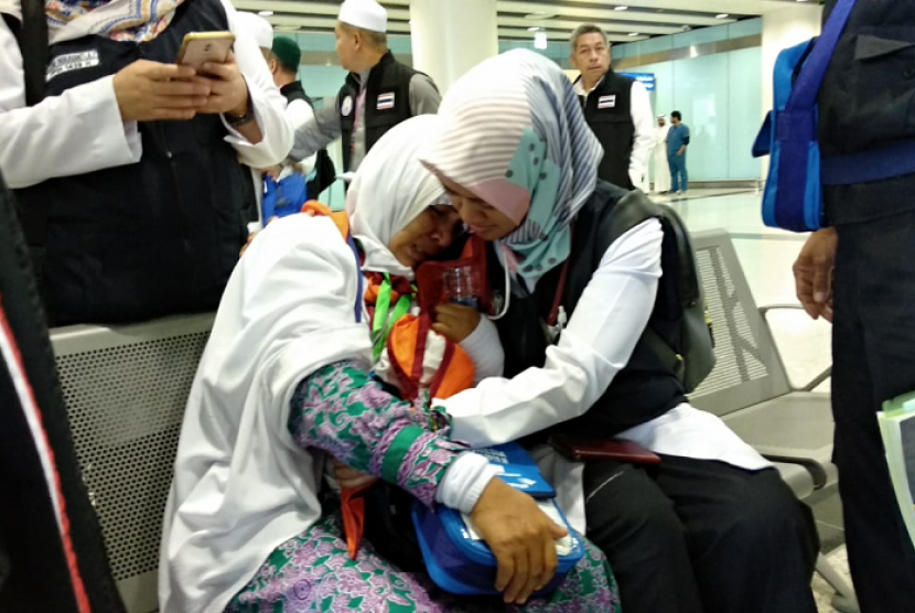 Petugas menenangkankan Asmia Hadi Hasan, seorang jamaah asal Gowa, Sulawesi Selatan, yang ditinggal wafat ibunya di Bandara Amir Muhammad bin Abdulaziz, Madinah, Jumat (20/7).