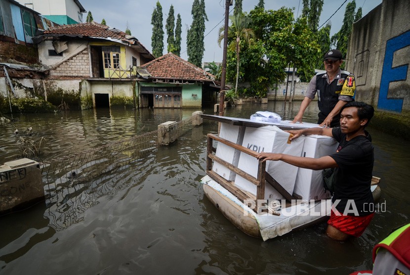 Petugas menerjang banjir dengan menggunakan perahu saat mendistribusikan logistik keperluan Pemilu dan Pileg di Desa Bojongasih, Dayeuhkolot, Kabupaten Bandung, Jawa Barat, Selasa (16/4/2019). 