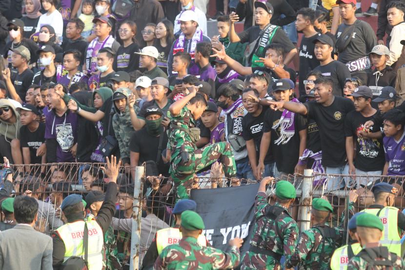 Petugas mengamankan suporter saat laga Liga 1 angara Persik Kediri melawan Arema FC di Stadion Brawijaya, Kota Kediri, Jawa Timur, Sabtu (17/9/2022). 