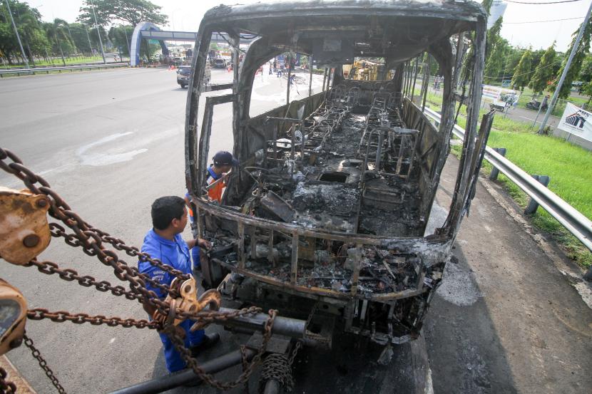 Petugas mengamati bus pariwisata yang terbakar. (Ilustrasi)