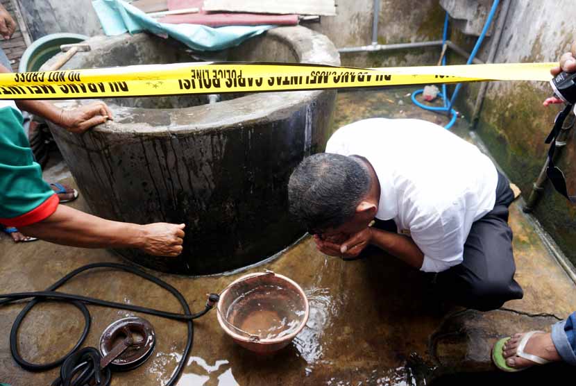 Petugas mengambil air di dalam sumur milik Mudrikatin yang berubah menjadi panas di Desa Ngemplak, Perak, Jombang, Jawa Timur, Senin (1/12).     