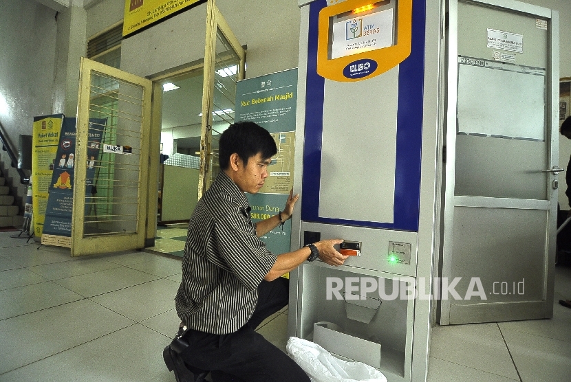 Petugas mengambil beras dari mesin ATM beras di Komplek Masjid Salman, Jl Ganesha, Kota Bandung, Selasa (29/11).
