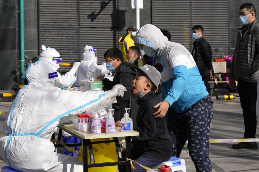 Petugas mengambil sampel ait liur seorang warga di Beijing China, Senin (14/3/2022). Pihak berwenang China melaporkan 1.337 kasus Covid-19 yang ditularkan secara lokal di puluhan kota daratan pada Senin (14/3/2022).